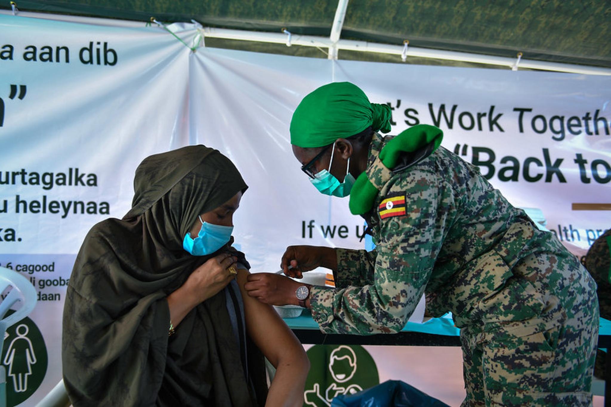 Image of Somalian woman shopkeeper getting Covid-19 vaccination by AMISOM Public Information at https://flic.kr/p/2mk63ji (CC0 1.0)