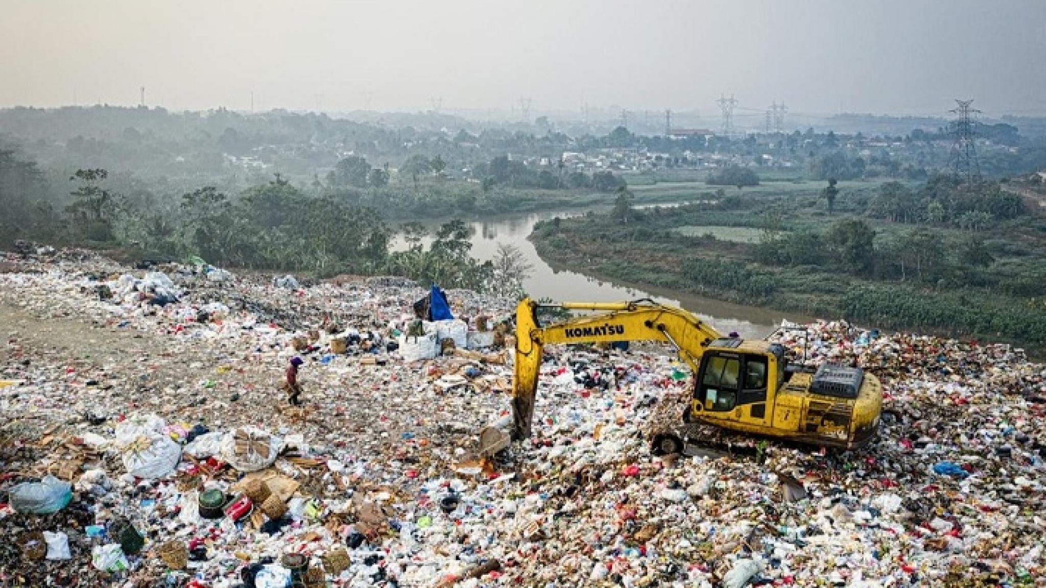 Drone photo of dumpsite in foreground and hazy horizon in background, indicating pollution, by Tom Fisk, free to use under pexels licence