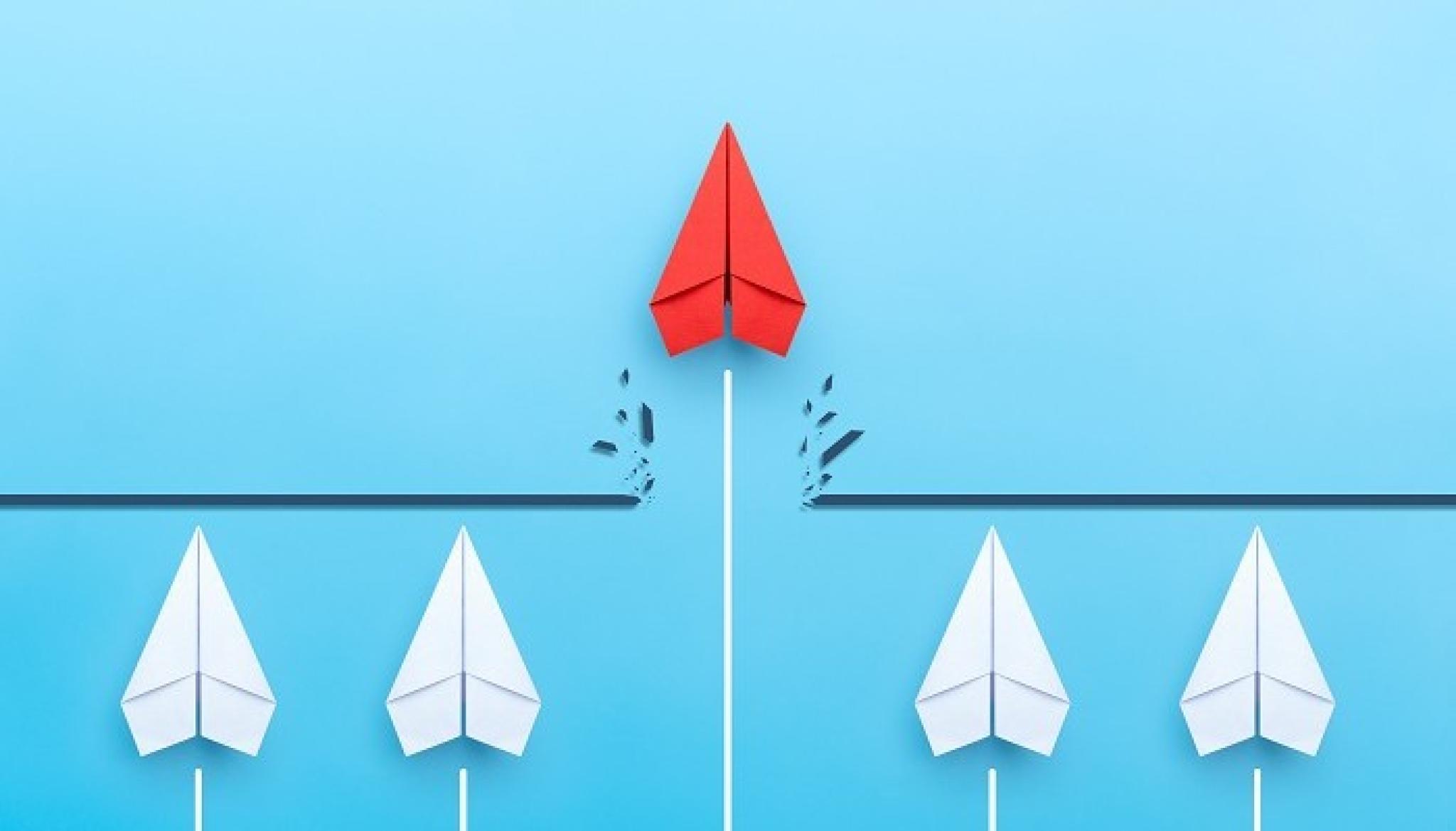 Illustration of red paper plane breaking through a wall holding back white paper planes, by Worawut, from Adobe Stock, used under Educational Licence.