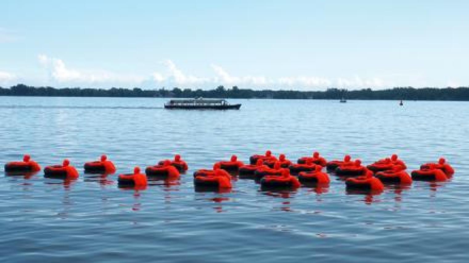 Image: 25 figures clinging to inner tubes. Each represents more than one million refugees in the world. James Beheshti (Unsplash)