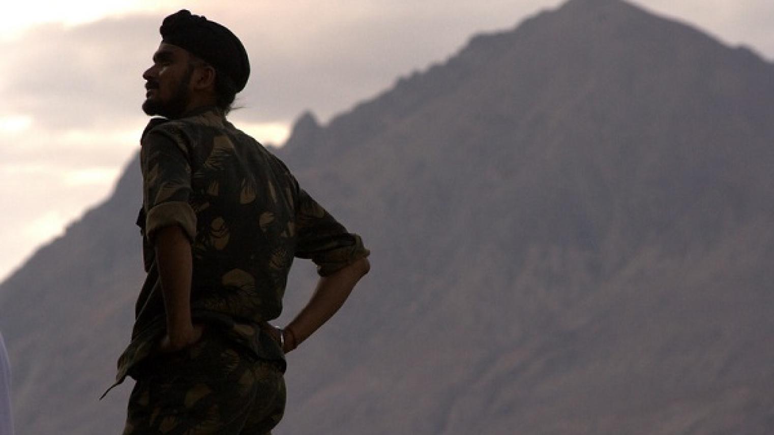 Obscure image of an Indian army jawan (infantryman) standing against the Himalayan backdrop in Nubra valley, Ladakh by Rahul Venkatram on flickr, used under CC BY-NC-ND 2.0 licence.